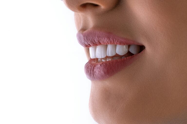 A patient looking at a digital tablet showing a side-by-side 3D simulation of their face before and after a full smile makeover.